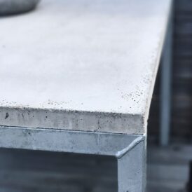 Detaljbild på ett matbord i betong och galvaniserat benstativ från Grafitgrå.