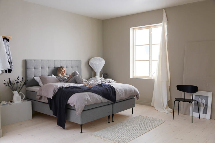 Miljöbild på Hilding Original kontinentalsäng med vägghängd sänggavel i tyget eco grå.