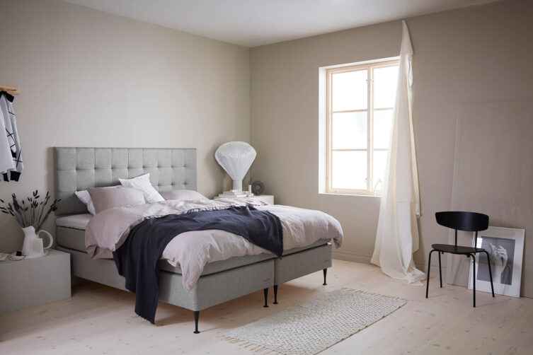 Miljöbild på Hilding Original kontinentalsäng med vägghängd sänggavel i tyget eco grå.