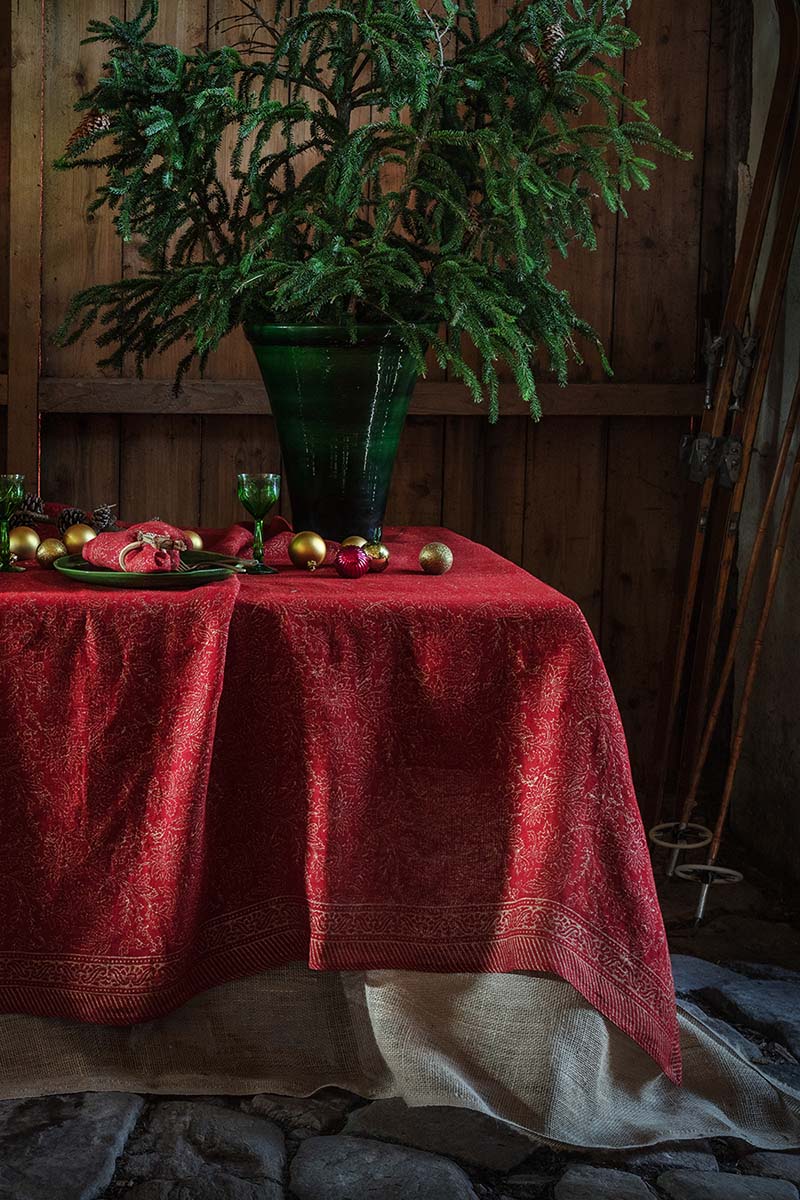 Miljöbild på bordsduk i rödd och guld från Chamois.