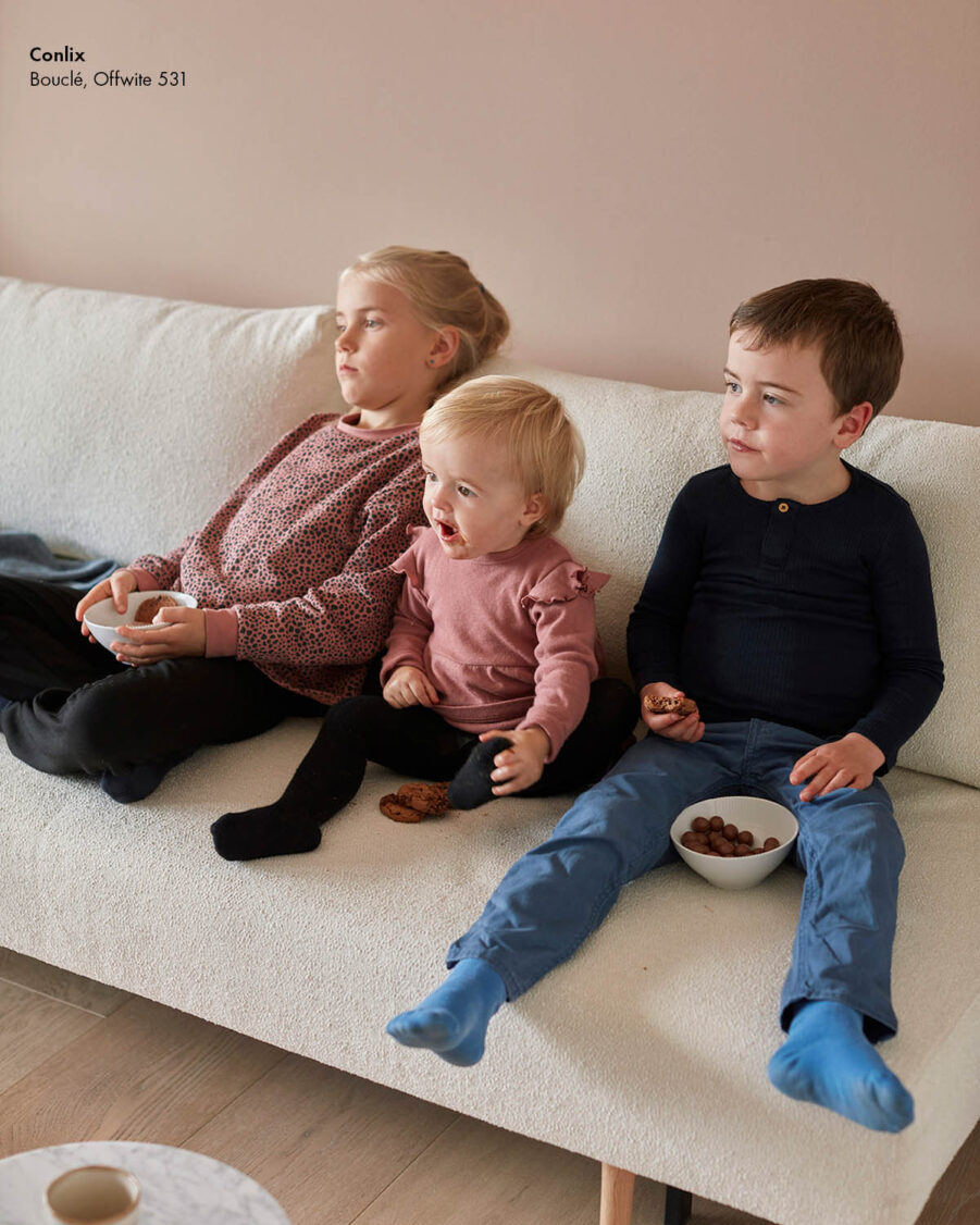 Bild på barn som äter choklad på en vit Colix-soffa med avtagbar klädsel.