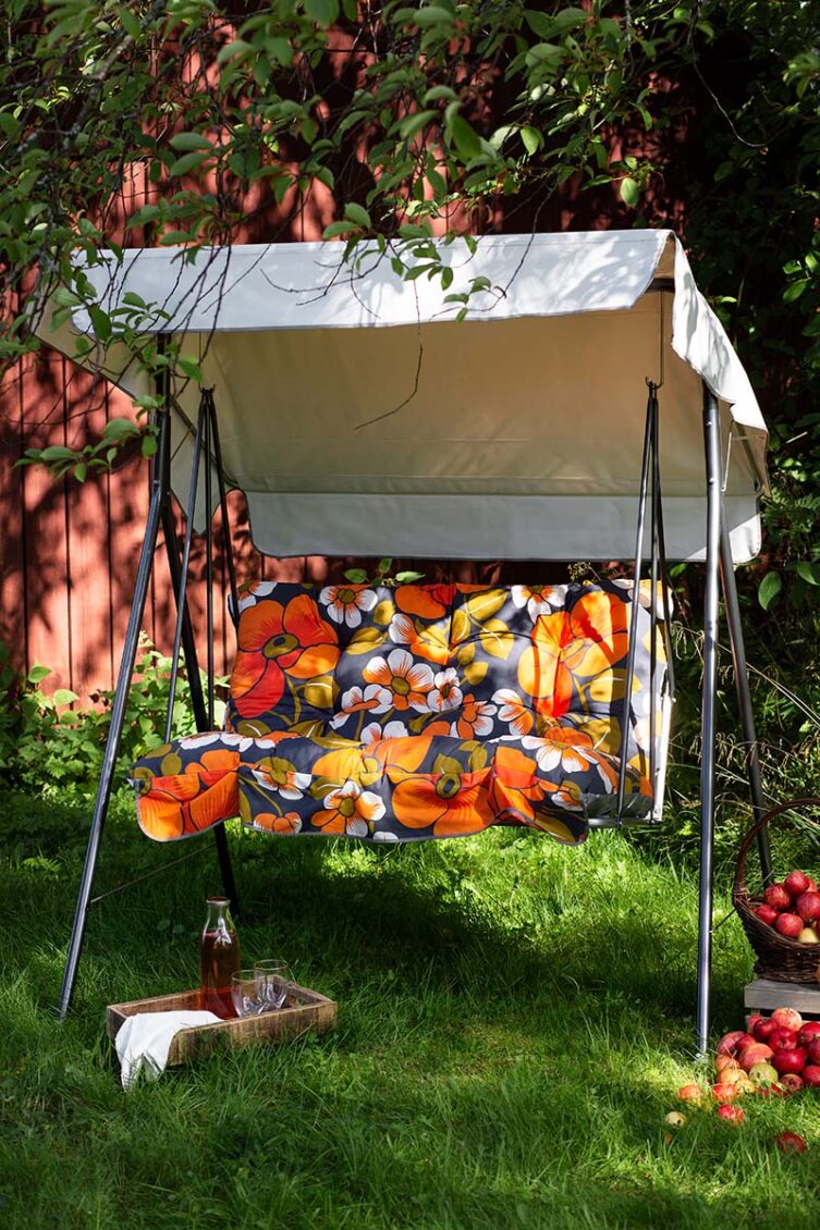 Miljöbild på Duetto hammock i grått med blommig dyna.