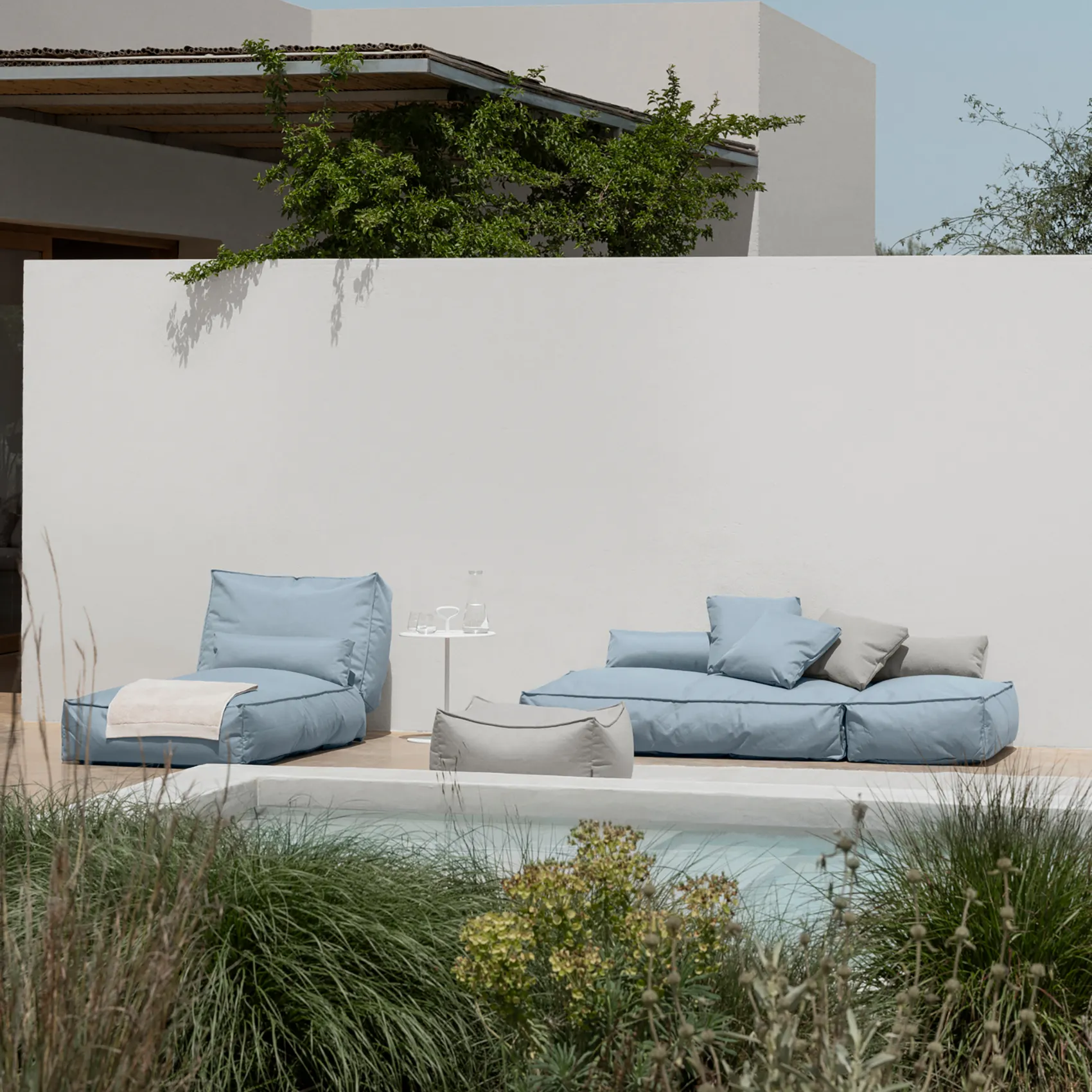 Två stycken Stay ocean dagbäddar vid en pool, en med nedfälld rygg.