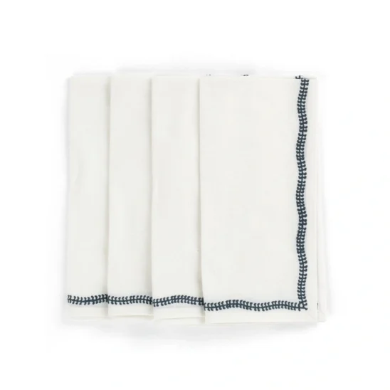 Embroidery servetter i vitt med marinblått broderi.