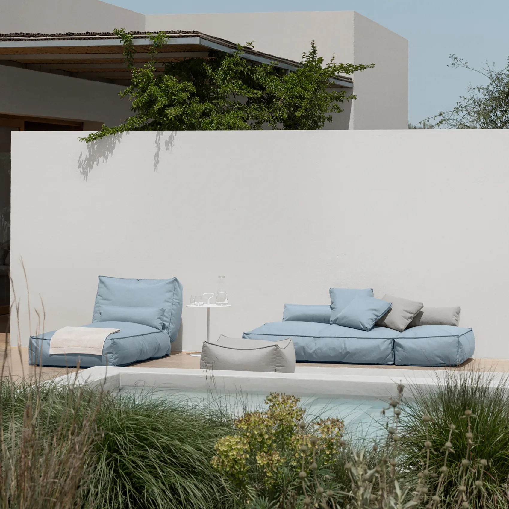 Stay dagbäddar i tyget ocean i miljö vid en pool, ena bädden har nedfälld rygg.